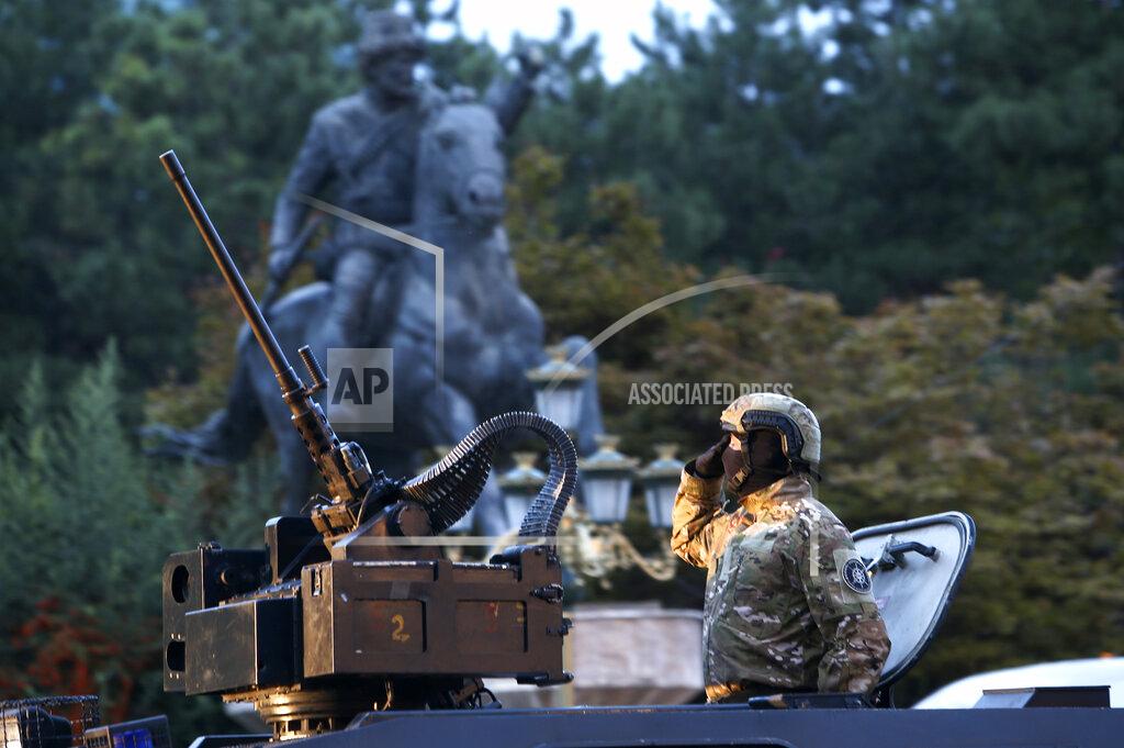 Boris Grdanoski Police officer atop an armored personal carrier salutes during a parade to mark the Independence Day in downtown Skopje, North Macedonia, Wednesday, Sept. 8, 2021. North Macedonia is celebrating Wednesday the 30th anniversary since its independence from former Yugoslavia. (AP Photo/Boris Grdanoski)