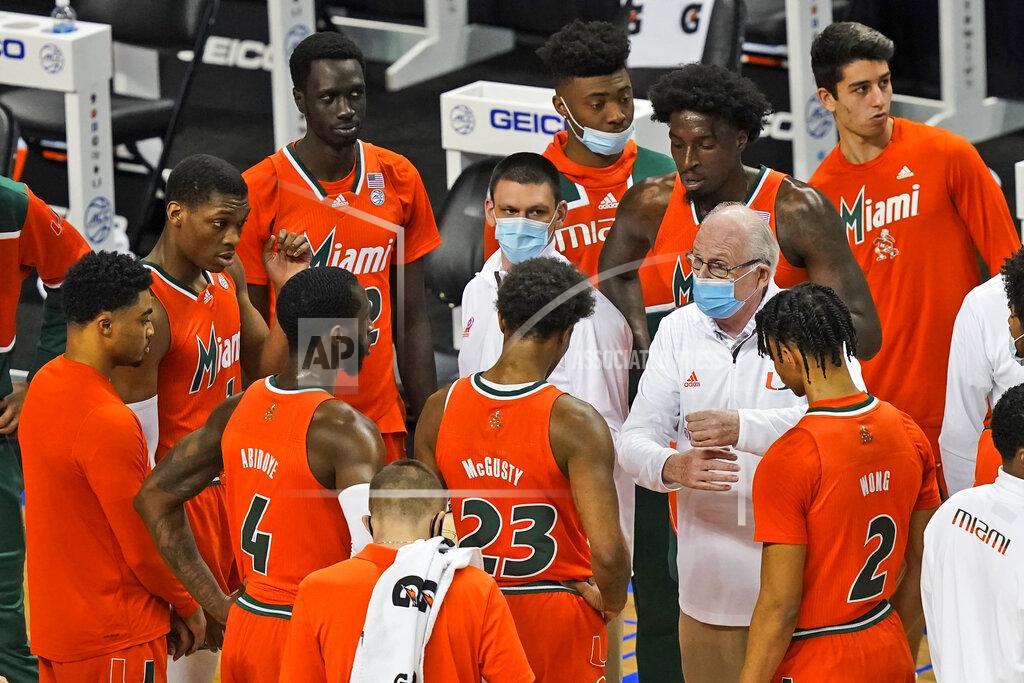 Gerry Broome Miami head coach Jim Larrañaga, right white shirt, talks to his team during the first half an NCAA college basketball game in the first round of the Atlantic Coast Conference tournament in Greensboro, N.C., Tuesday, March 9, 2021. (AP Photo/Gerry Broome)