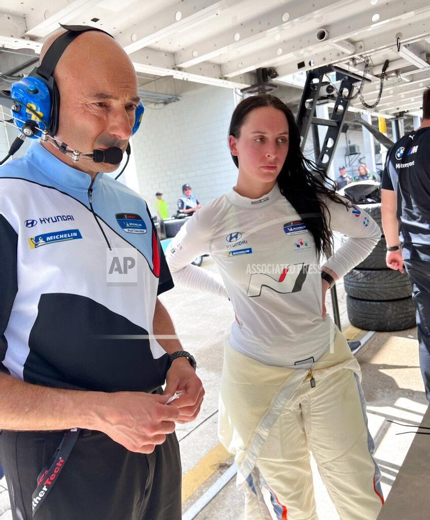 IMSA sports car driver Taylor Hagler, right, looks at data with engineer Stefano Galante on Wednesday March 16, 2022, at Sebring International Raceway in Sebring, Fla. Hagler drives for Bryan Herta Autosport and is the second female champion in IMSA history. She races Thursday at Sebring in The Michelin Pilot Challenge race. (AP Photo/Jenna Fryer)