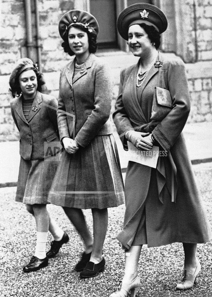 Uncredited FILE - Princess Elizabeth, 16, center, appears with her mother, Queen Elizabeth, and her younger sister, Princess Margaret Rose, as they walk to the parade ground of Windsor Castle for a review of the Grenadier Guards on May 19, 1942 in Windsor. Queen Elizabeth II's style has been hyper-documented since her birth, young princess days, ascension to the throne and now, more than 70 years into her reign.(AP Photo, File)