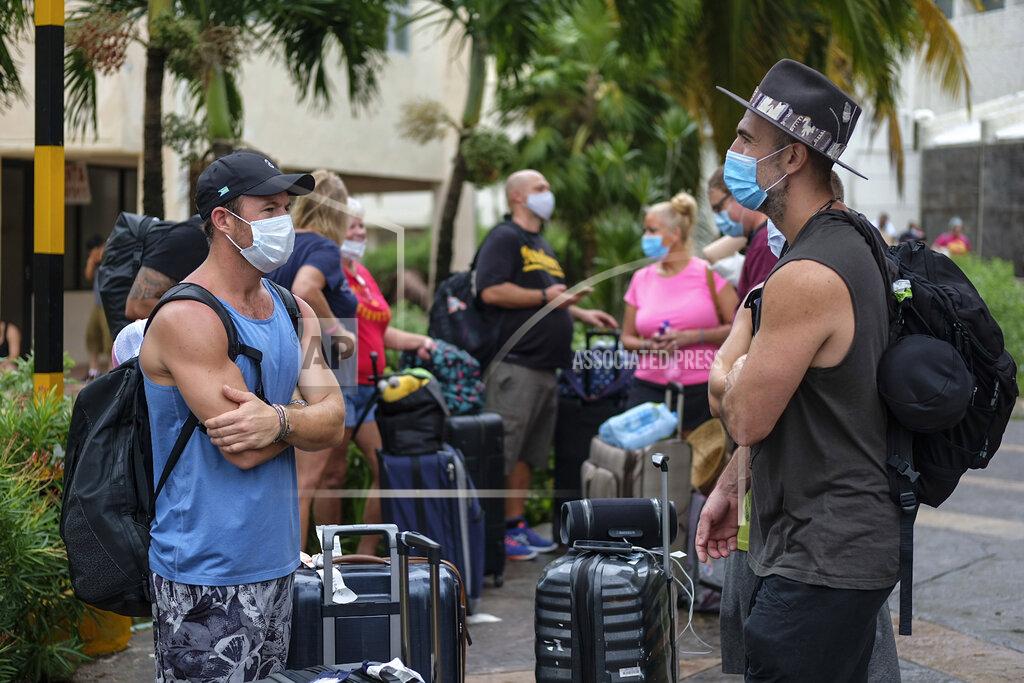 Victor Ruiz Garcia Tourists wait for transportation to return to their hotels after sleeping in a shelter following the passing of Hurricane Delta in Cancun, Mexico, Wednesday, Oct. 7, 2020. Hurricane Delta made landfall Wednesday just south of the Mexican resort of Cancun as a Category 2 storm, downing trees and knocking out power to some resorts along the northeastern coast of the Yucatan Peninsula. (AP Photo/Victor Ruiz Garcia)