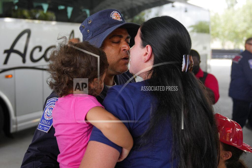 Rebecca Blackwell A rescue worker greets his loved ones as members of Miami-Dade Fire Rescue's urban search and rescue team are reunited with their families after weeks of working on the rubble pile at the collapsed Champlain Towers South condominium, on Friday, July 23, 2021, in Doral, Fla. (AP Photo/Rebecca Blackwell)