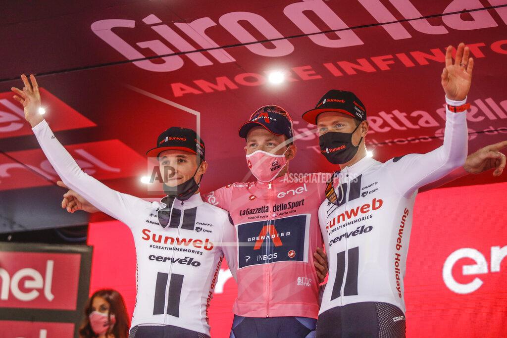 Luca Bruno Britain's Tao Geoghegan Hart, center, winner of the Giro d'Italia cycling race, poses on the podium with second placed Australia's Jai Hindley, left, and third placed Wilco Kelderman, of The Netherlands, in Milan, Italy, Sunday, Oct. 25, 2020. (AP Photo/Luca Bruno)