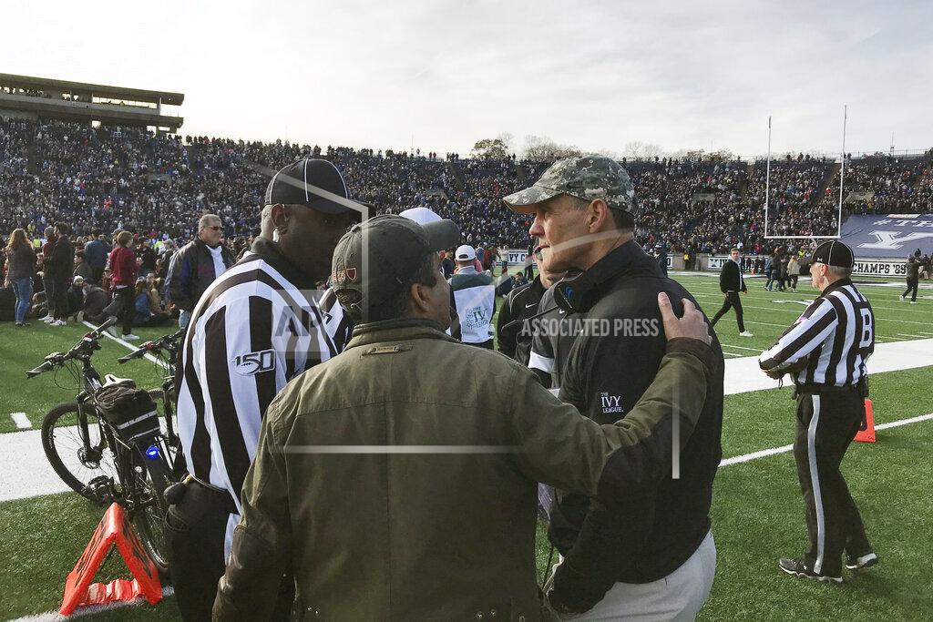 Jimmy Golen Harvard coach Tim Murphy, right, gets an updated as demonstrators stage a protest on the field at the Yale Bowl disrupting the start of the second half of an NCAA college football game between Harvard and Yale, Saturday, Nov. 23, 2019, in in New Haven, Conn. (AP Photo/Jimmy Golen)