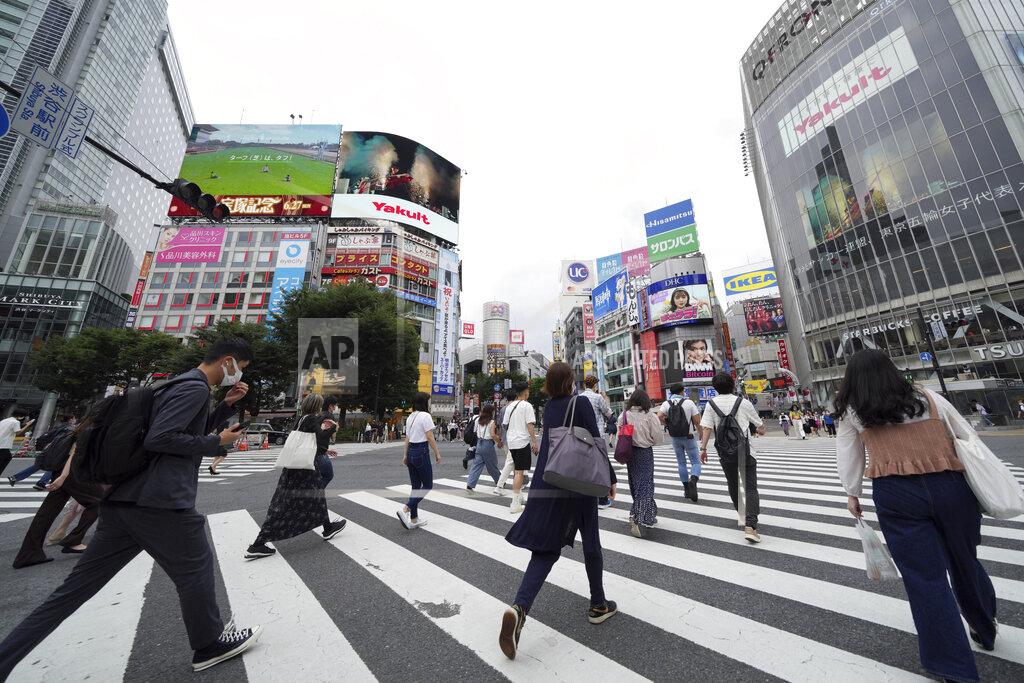 Eugene Hoshiko People wearing protective masks to help curb the spread of the coronavirus walk along a pedestrian crossing Thursday, June 24, 2021, in Tokyo. (AP Photo/Eugene Hoshiko)