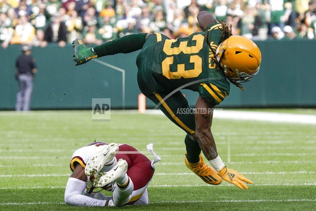 Morry Gash Green Bay Packers' Aaron Jones is tripped up by Washington Football Team's Danny Johnson during the first half of an NFL football game Sunday, Oct. 24, 2021, in Green Bay, Wis. (AP Photo/Morry Gash)