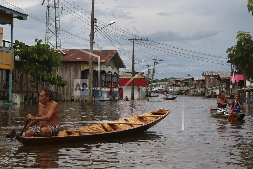 Edmar Barros Residents navigate flooded streets in Anama, Amazonas state, Brazil, Thursday, May 13, 2021. (AP Photo/Edmar Barros)