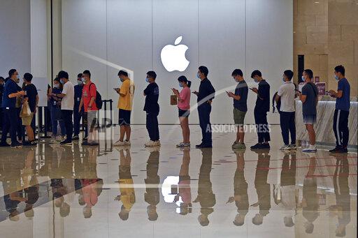 People line up at an Apple Store to buy the latest iPhone 13 handsets in Nanning in south China's Guangxi Zhuang Autonomous Region on Sept. 24, 2021. Global shoppers face possible shortages of smartphones and other goods ahead of Christmas after power cuts to meet government energy use targets forced Chinese factories to shut down and left some households in the dark. (Chinatopix Via AP)