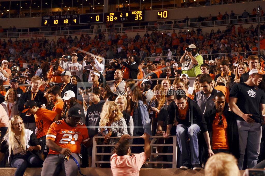Brody Schmidt Oklahoma State fans jump down from the stadium wall to take the field following an NCAA college football game against Texas, in Stillwater, Okla., Saturday, Oct. 27, 2018. Oklahoma State defeated Texas 38-35. (AP Photo/Brody Schmidt)