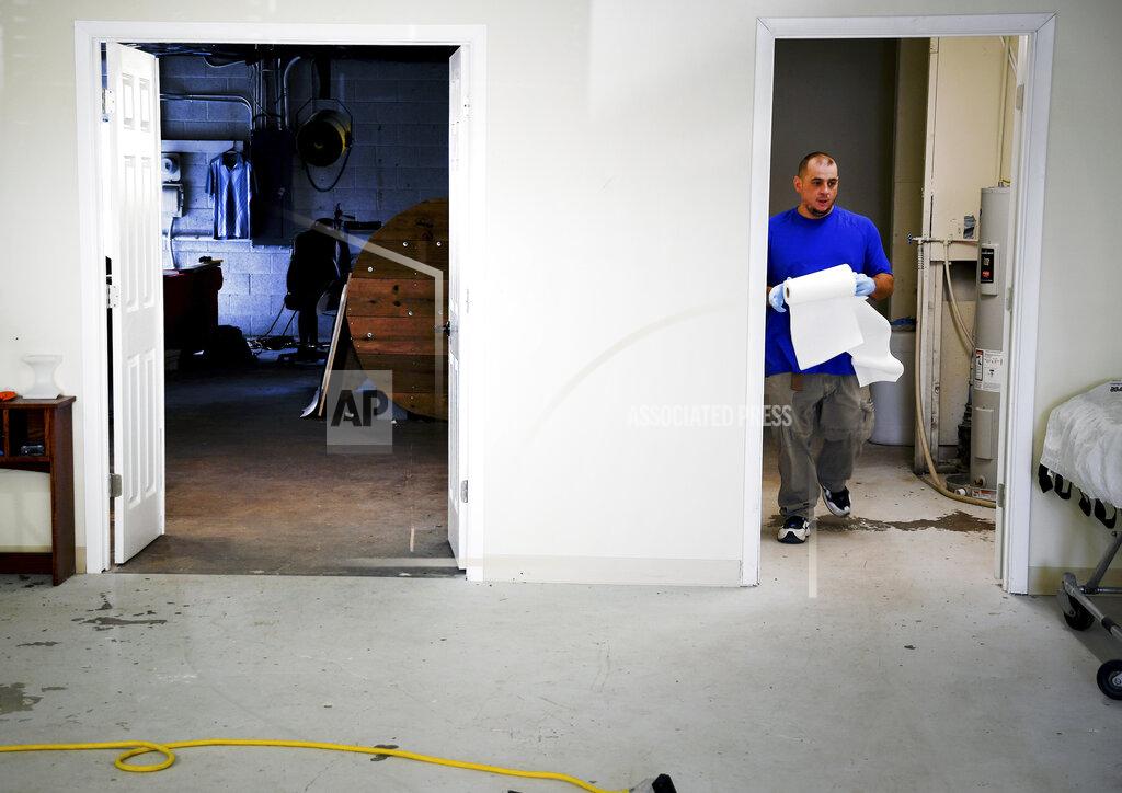 Thomas Peipert In this Wednesday, Aug. 11, 2021, photo, employee Chris Olachia walks through The Natural Funeral's human body composting facility in Arvada, Colo. On Sept. 7, Colorado became the second state after Washington to allow human body composting, and Oregon will allow the practice beginning next July. Vessels will be packed with wood chips and straw and will be able to compost a body in six months. (AP Photo/Thomas Peipert)