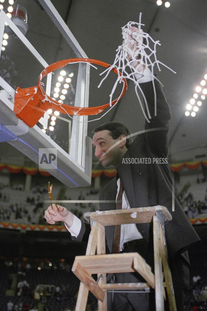 FILE - In this April 2, 1991, file photo, Duke coach Mike Krzyzewski finishes the traditional net cutting in the Indianapolis Hoosier Dome after Duke defeated Kansas 72-65 in the NCAA Final Four championship game. Recouping from a 30-point loss in last year's NCAA championship game, Duke beat top-ranked UNLV and then Kansas to win the championship for the first time. (AP Photo/Bob Jordan, File)