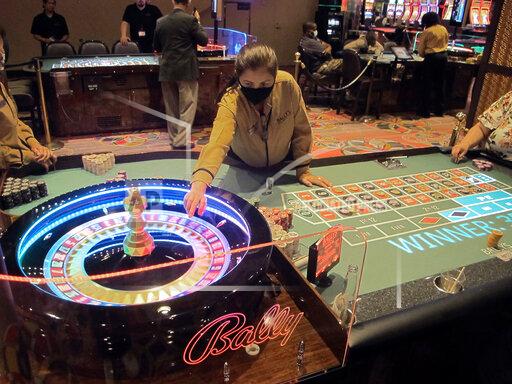 This June 23, 2021 photo shows a dealer conducting a game of roulette at Bally's casino in Atlantic City, N.J. Rhode Island-based Bally's Corp. is spending $100 million on renovations to the property, which ranks last among Atlantic City's nine casinos in terms of gambling revenue. (AP Photo/Wayne Parry)