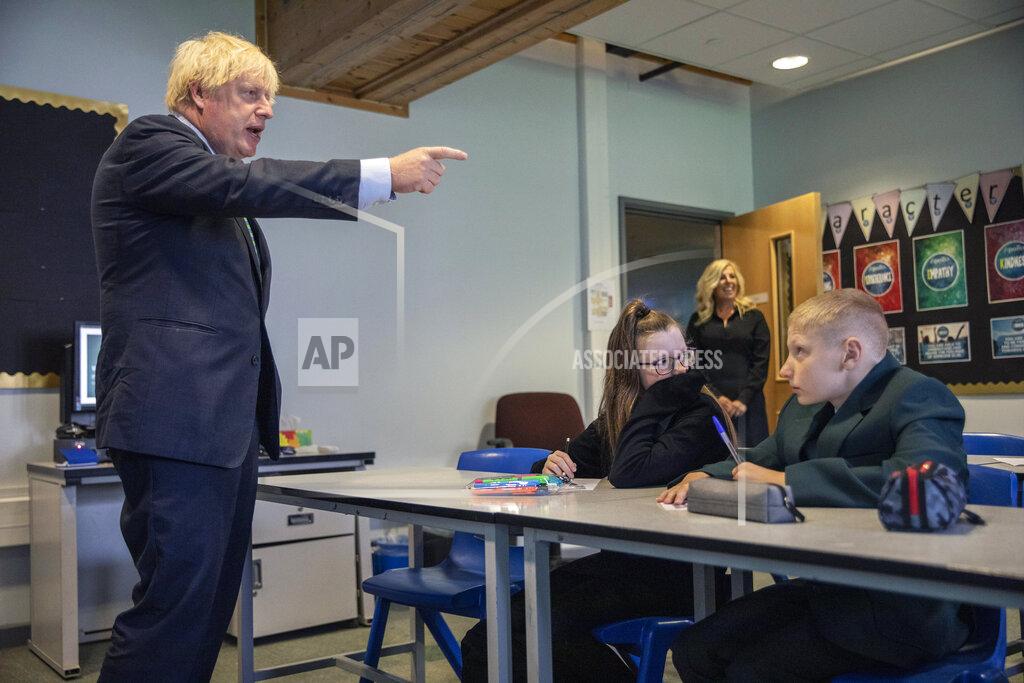 FILE - In this Wednesday, Aug. 26, 2020 file photo, Britain's Prime Minister Boris Johnson gestures during a visit to Castle Rock school on the pupils' first day back, in Coalville, East Midlands, England. Johnson is announcing plans Monday, Feb. 22, 2021 to ease restrictions in increments, starting by reopening schools in England on March 8. People will be allowed to meet one friend or relative for a chat or picnic outdoors from the same day. Three weeks later, people will be able to meet outdoors in groups of up to six outdoors. But restaurants, pubs, gyms and hairdressers are likely to remain closed until at least April. (Jack Hill/Pool Photo via AP, File)