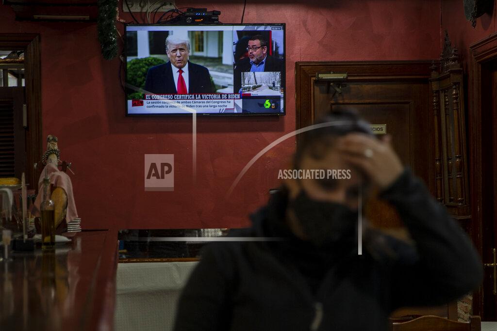 Manu Fernandez A waiter gestures in front a TV screen broadcasting news reports on U.S. President Donald Trump, in Rivas Vaciamadrid, Spain, Thursday, Jan. 7, 2021. Congress confirmed Democrat Joe Biden as the presidential election winner early Thursday after a violent mob loyal to President Donald Trump stormed the U.S. Capitol in a stunning attempt to overturn America's presidential election. (AP Photo/Manu Fernandez)
