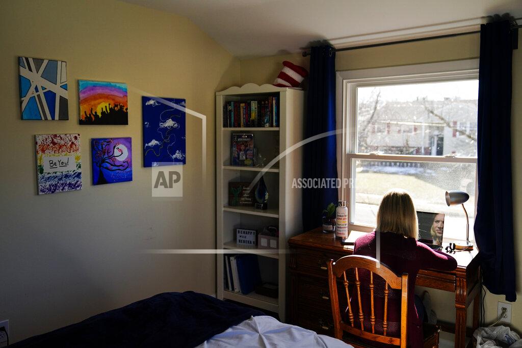 Matt Rourke Rebekah Bruesehoff, 14, works on school assignments at home in New Jersey, Friday, Feb. 26, 2021. While New Jersey has a trans-inclusive sports policy, the field hockey player is distressed by proposed bans elsewhere – notably measures that might require girls to verify their gender. “I know what it’s like to have my gender questioned,” Rebekah said. “It’s invasive, embarrassing. I don’t want others to go through that.” (AP Photo/Matt Rourke)