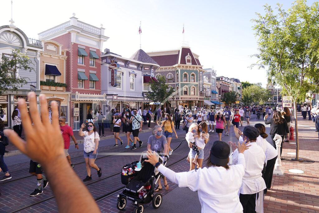 FILE - In this April 30, 2021, file photo, guests walk down Main Street USA at Disneyland in Anaheim, Calif. Los Angeles and San Francisco are reopening more businesses under California's least restrictive coronavirus safety rules, even though they have more infections than many other big counties, state data shows. (AP Photo/Jae Hong, File)