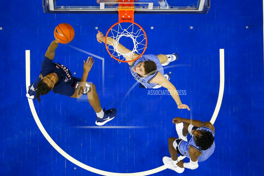 Chris Szagola Connecticut's Brendan Adams, left, shoots the ball with Villanova's Cole Swider, center, defending during the first half of an NCAA college basketball game Saturday, Jan. 18, 2020, in Philadelphia. (AP Photo/Chris Szagola)