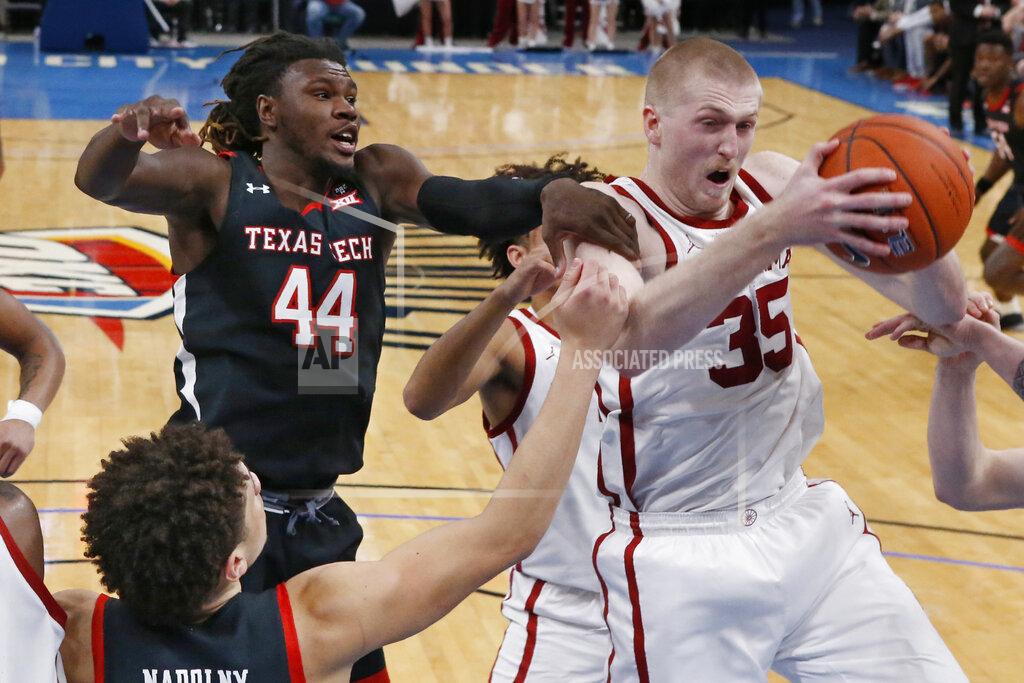 Sue Ogrocki Oklahoma forward Brady Manek (35) grabs a rebound in front of Texas Tech guard Chris Clarke (44) and guard Clarence Nadolny, left, in the second half of an NCAA college basketball game Tuesday, Feb. 25, 2020, in Oklahoma City. (AP Photo/Sue Ogrocki)