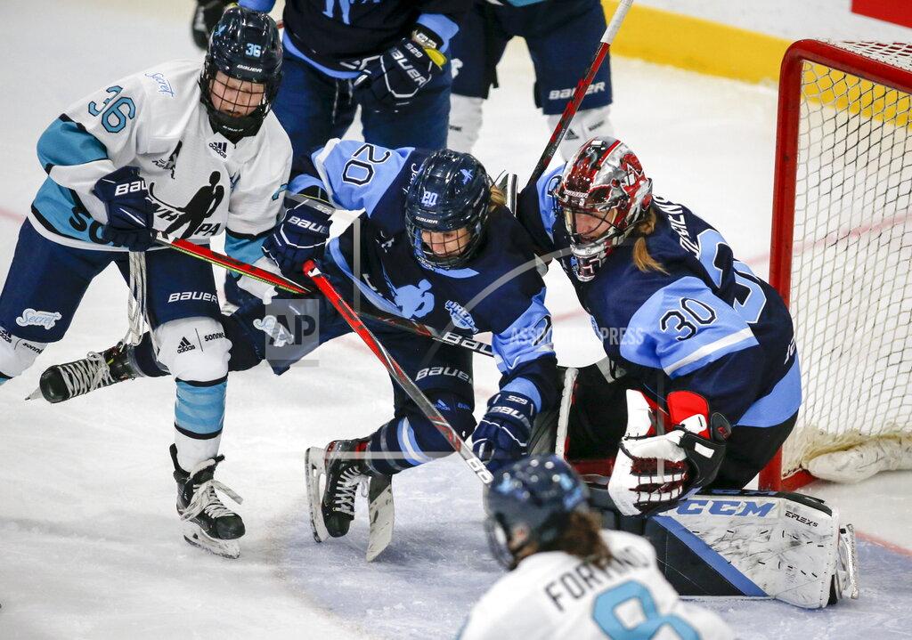Jeff Mcintosh Team Bauer Kristin O'Neill, center, is knocked into her goalie Ann-Renee Desbiens, right, by Team Sonnet Loren Gabel during first-period PWHPA Dream Tour hockey game action in Calgary, Alberta, Monday, May 24, 2021. (Jeff McIntosh/The Canadian Press via AP)