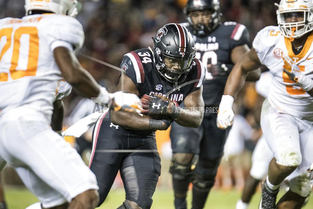 Sean Rayford South Carolina running back Mon Denson (34) runs with the ball between Tennessee defensive lineman Kyle Phillips (5) and Bryce Thompson (20) during the second half of an NCAA college football game Saturday, Oct. 27, 2018, in Columbia, S.C. South Carolina defeated Tennessee 27-24. (AP Photo/Sean Rayford)