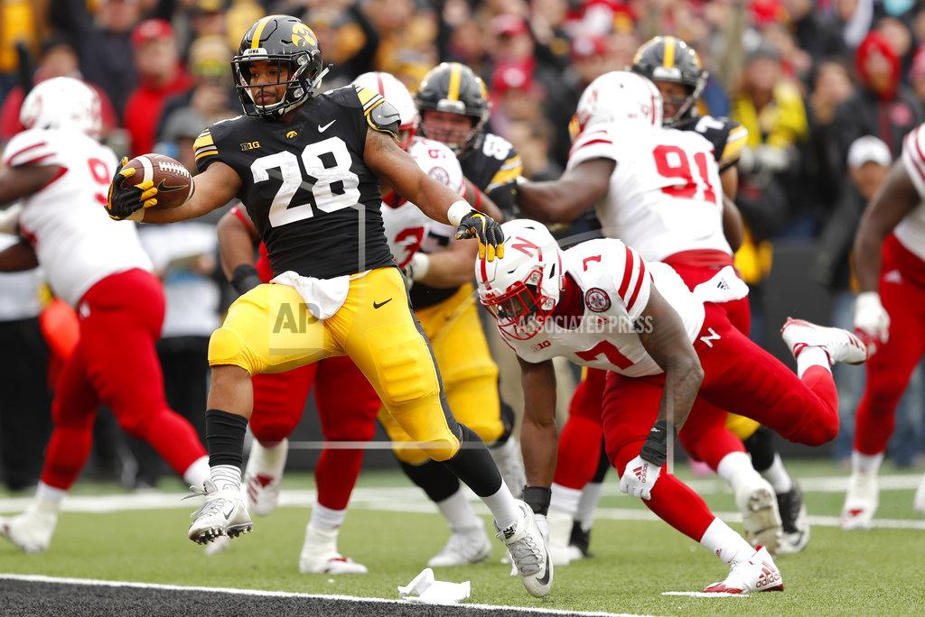 Charlie Neibergall Iowa running back Toren Young (28) runs from Nebraska linebacker Mohamed Barry (7) during a 4-yard touchdown run in the first half of an NCAA college football game, Friday, Nov. 23, 2018, in Iowa City, Iowa. (AP Photo/Charlie Neibergall)