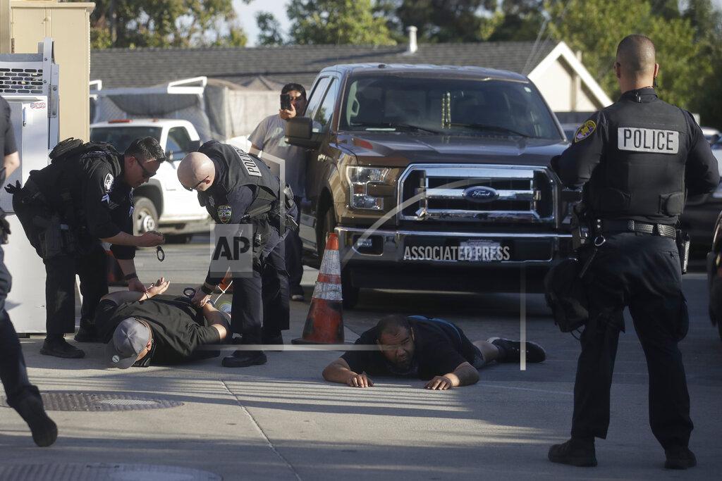 Jeff Chiu Police officers apprehend two men in Redwood City, Calif., Tuesday, June 2, 2020, as protesters marched nearby over the death of George Floyd. Floyd died May 25 after being restrained by Minneapolis police. (AP Photo/Jeff Chiu)