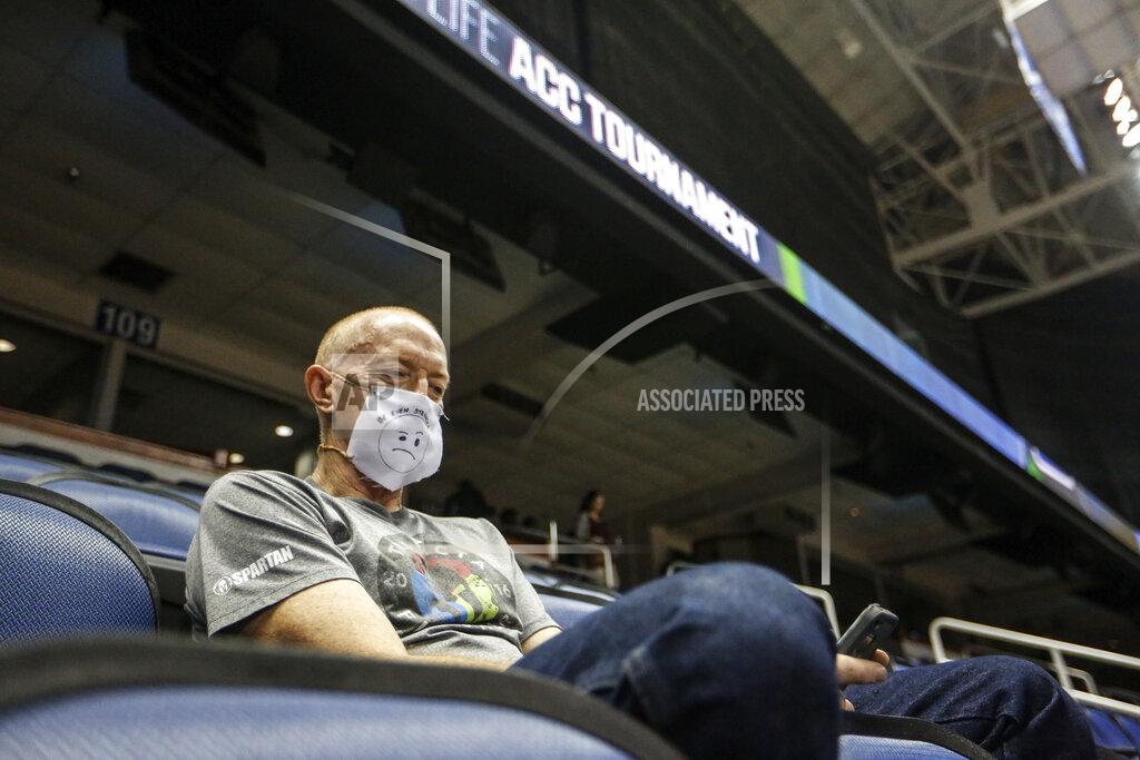 Khadejeh Nikouyeh Mike Lemcke, from Richmond, Va., sits in an empty Greensboro Coliseum after the NCAA college basketball games were cancelled at the Atlantic Coast Conference tournament in Greensboro, N.C., Thursday, March 12, 2020. The biggest conferences in college sports all canceled their basketball tournaments because of the new coronavirus, seemingly putting the NCAA Tournament in doubt. The vast majority of people recover from the new coronavirus. According to the World Health Organization, most people recover in about two to six weeks, depending on the severity of the illness. (Khadejeh Nikouyeh/News & Record via AP)