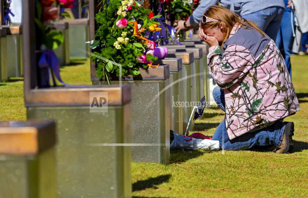 Chris Landsberger A person kneels at the memorial chair of Robbin Ann Huff and baby Amber Denise Huff in the Field of Chairs during the 26th Anniversary Remembrance Ceremony at the Oklahoma City National Memorial and Museum in Oklahoma City, Okla on Monday, April 19, 2021. (Chris Landsberger/The Oklahoman via AP)
