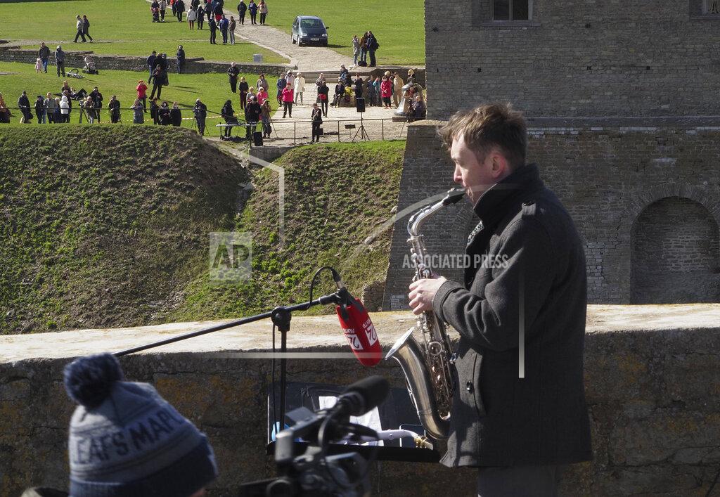 Dmitri Lovetsky Estonian guitarist Jaak Sooaar, in the background center, performs in the Narva Castle in Narva as Russian saxophonist Alexey Kruglov, right, performs in the Ivangorod Fortress on the Russian-Estonian border in Ivangorod, 130 km (80 miles) west of St.Petersburg, Russia, Friday, April 30, 2021. Musicians on the Estonian-Russian border held an unusual concert on Friday, with Estonian guitarist Jaak Sooaar and Russian saxophonist Alexey Kruglov performing from the castles on the opposing banks of the Narva river that marks the border between the two countries. The concert was held on the International Jazz Day by the two musicians as an act of friendship despite the deteriorating relations between the two countries and as cross-border contacts have been limited due to the corona-virus pandemic. (AP Photo/Dmitri Lovetsky)