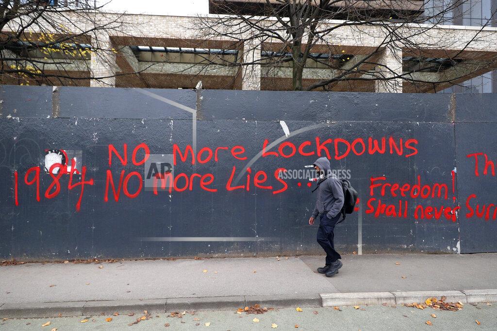 Peter Byrne A man walks past anti-lockdown graffiti in Manchester, England, Monday, Oct. 19, 2020 as the row over Greater Manchester region's coronavirus status continues. Britain’s government says discussions about implementing stricter restrictions in Greater Manchester must be completed Monday because the public health threat caused by rising COVID-19 infections is serious and getting worse. (Peter Byrne/PA via AP)