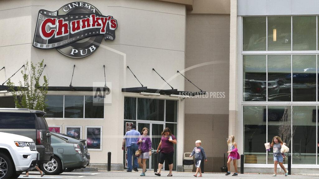 Moms with their children head to their cars after viewing the midday showing of "The Greatest Showman" at the Chunky's Cinema Pub on Monday, June 29, 2020, in Manchester, New Hampshire. Movie theaters, which have been closed since mid-March, were allowed to reopen on Monday with safety restrictions. (AP Photo/Charles Krupa)