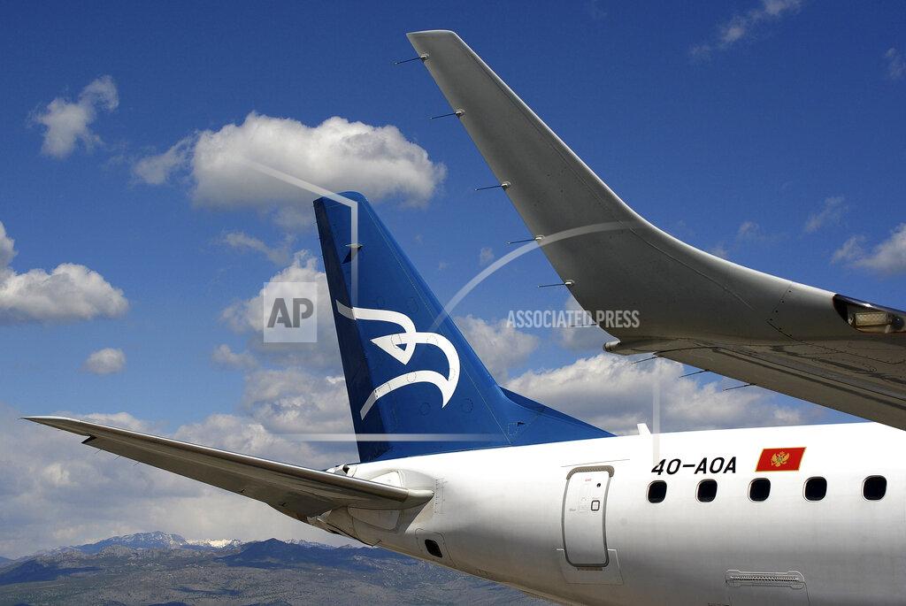 Risto Bozovic In this photo taken on April 10, 2014, Montenegro Airlines Embraer E195LR sits on the tarmac at the Golubovci airport, near Podgorica, Montenegro. Montenegro Airlines ceased its operations on Saturday, Dec. 26, 2020 after the small country's new government refused to continue financing the national carrier. The airline which was formed 25 years ago has apologized to its passengers for the sudden termination of all flights and thanked them for "the years of trust, travel and friendship." (AP Photo/Risto Bozovic)