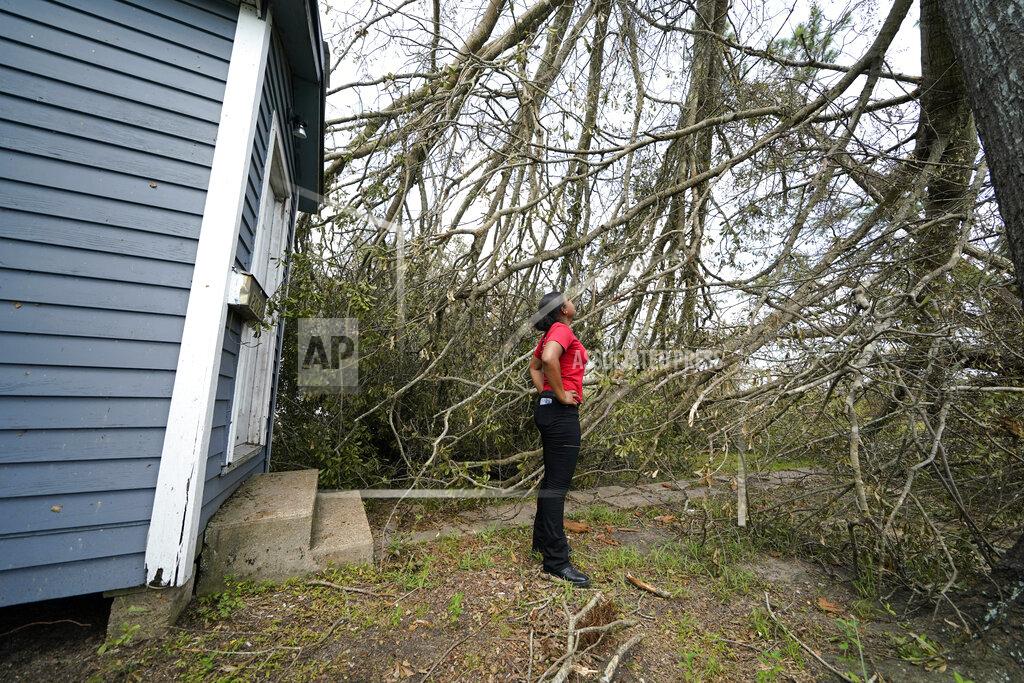 Gerald Herbert Layla Winbush looks at a fallen tree in front of her damaged home in Lake Charles, La., in the aftermath of Hurricane Laura, Sunday, Aug. 30, 2020. (AP Photo/Gerald Herbert)