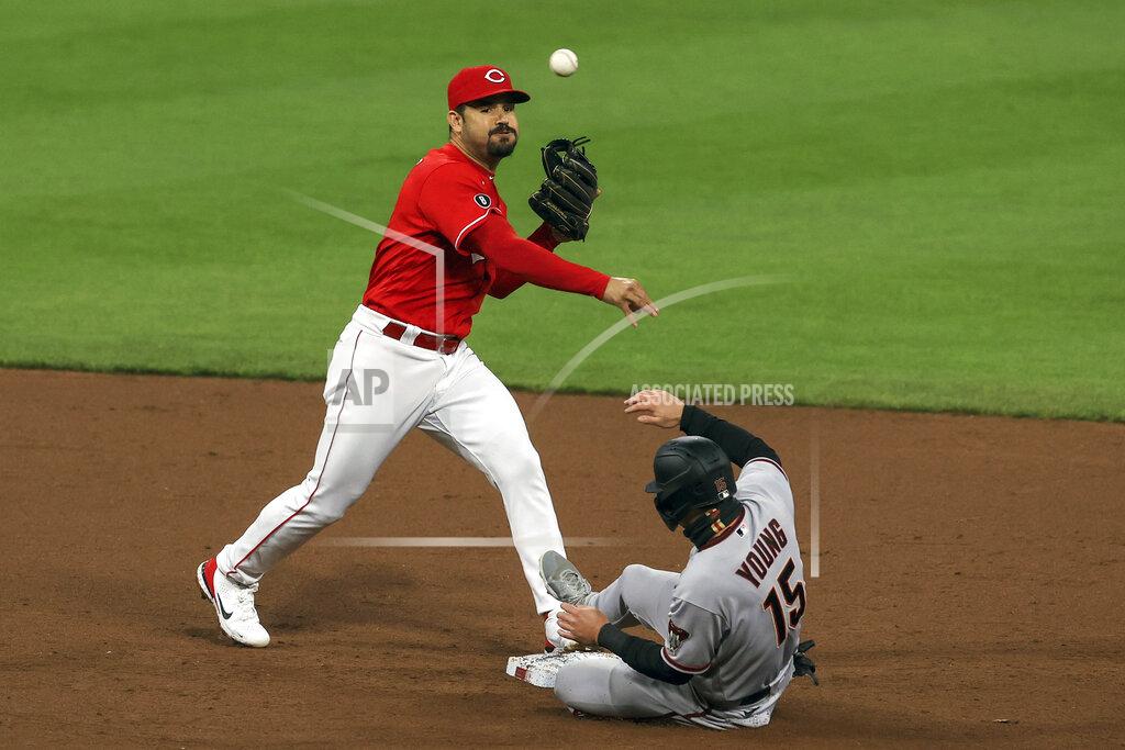 Aaron Doster Cincinnati Reds' Eugenio Suarez, left, throws to first to turn a double play as Arizona Diamondbacks' Andrew Young, right, is forced out at second base during the sixth inning of a baseball game in Cincinnati, Wednesday, April 21, 2021. (AP Photo/Aaron Doster)
