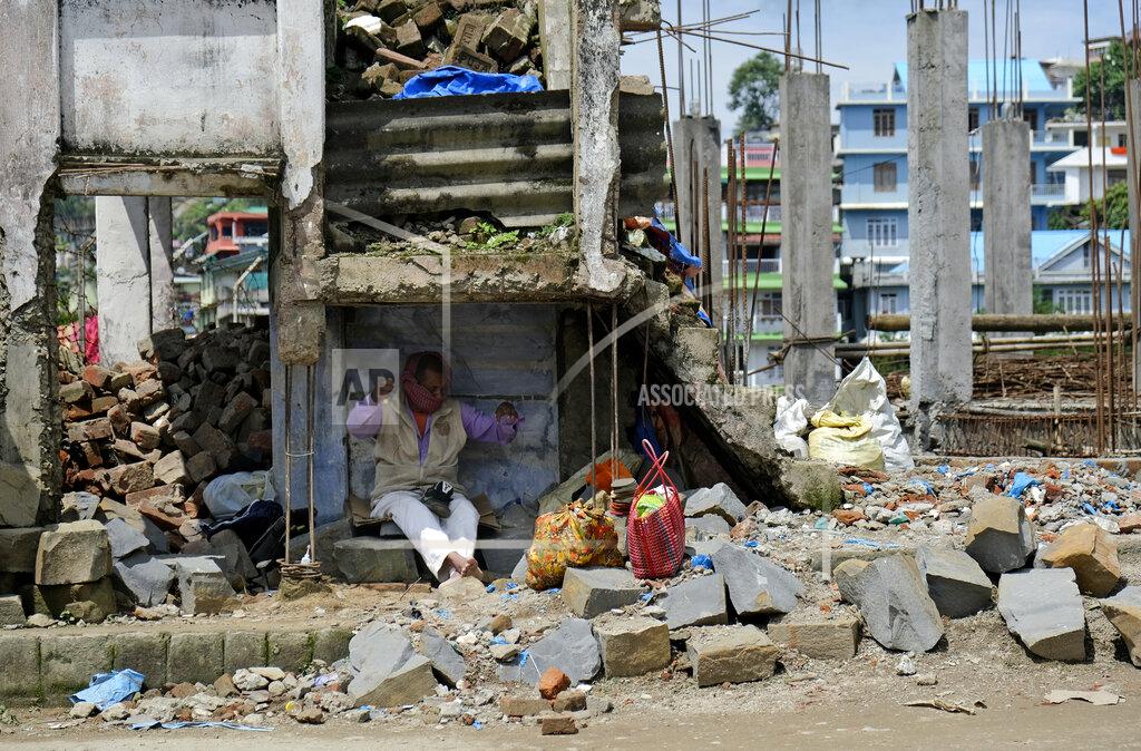 Yirmiyan Arthur A cobbler covers his face with a scarf and works in the shade of a dilapidated building in Kohima, capital of the northeastern Indian state of Nagaland, Friday, May 29, 2020. India’s economic growth will fall to 4.2% in financial year 2019-20 as compared to 6.1% in the previous year and likely to contract this year because of the coronavirus pandemic. Millions of workers have fled cities after losing their jobs as authorities imposed the lockdown in March and started easing it early this month to promote economic activity. (AP Photo/Yirmiyan Arthur)