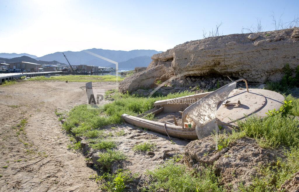 Steve Marcus A boat, previously abandoned and submerged, now sits in dried mud at the Callville Bay Marina in the Lake Mead National Recreation Area Tuesday, Sept. 14, 2021 in Las Vegas. Some businesses that depend on the Colorado River caught a wave of customers after coronavirus pandemic closures closed schools and offices. But boat rental and recreation company chief Chad Taylor says that receding water levels at Lake Mead, the river’s drought-stricken reservoir, have him constantly moving docks farther into Callville Bay. (Steve Marcus /Las Vegas Sun via AP)