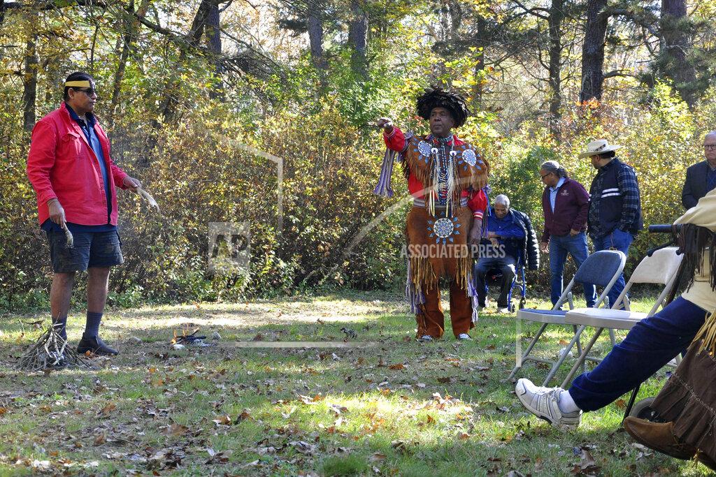 Alex Nunes Narragansett Indian Tribe Medicine Man and Historic Preservation Officer John Brown, left, and Chief Sachem Anthony Dean Stanton, right, participate in a ceremony, Saturday, Oct. 23, 2021, in a wooded area, in South Kingstown, R.I., on land they believe to be the site of the Great Swamp Massacre, The Public's Radio reported. The land where the Rhode Island Narragansett tribe survived near-annihilation in a battle with English colonists on Dec. 19, 1675, has been transferred to the tribe. The transfer of the land from the Rhode Island Historical Society was finalized Friday, Oct. 22. (Alex Nunes/The Public's Radio, WNPN 89.3FM via AP)