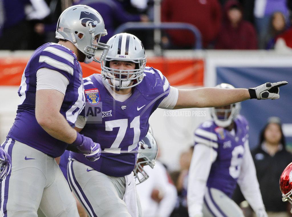 FILE - In this Jan. 2, 2016, file photo, Kansas State offensive lineman Dalton Risner (71) gestures at the line of scrimmage during the first half of the Liberty Bowl NCAA college football game against Arkansas in Memphis, Tenn. Risner has a future in the NFL. But he also hopes his future includes the growth and development of his foundation, RiseUp, which aims to provide hope and inspire young people. Eventually, he wants to establish a series of football-centric summer camps for kids that come from a variety of backgrounds. (AP Photo/Mark Humphrey, File)
