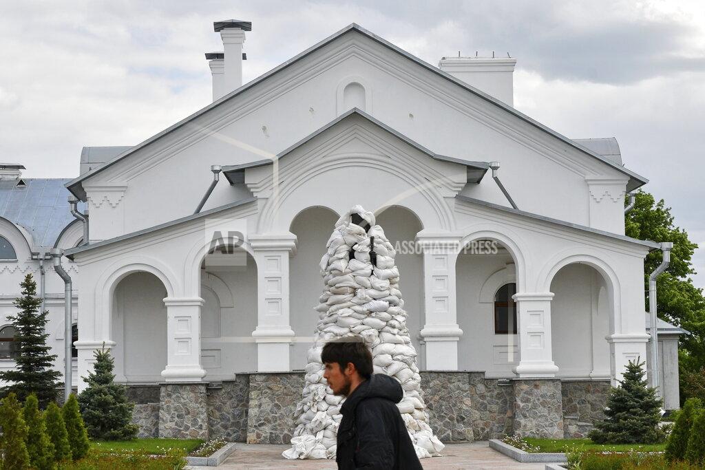Andriy Andriyenko A man walks past the monument of St. John of Shanghai covered with sandbags in a yard the Orthodox Skete in honour of St. John of Shanghai in Adamivka, near Slovyansk, Donetsk region, Ukraine, Tuesday, May 10, 2022. (AP Photo/Andriy Andriyenko)