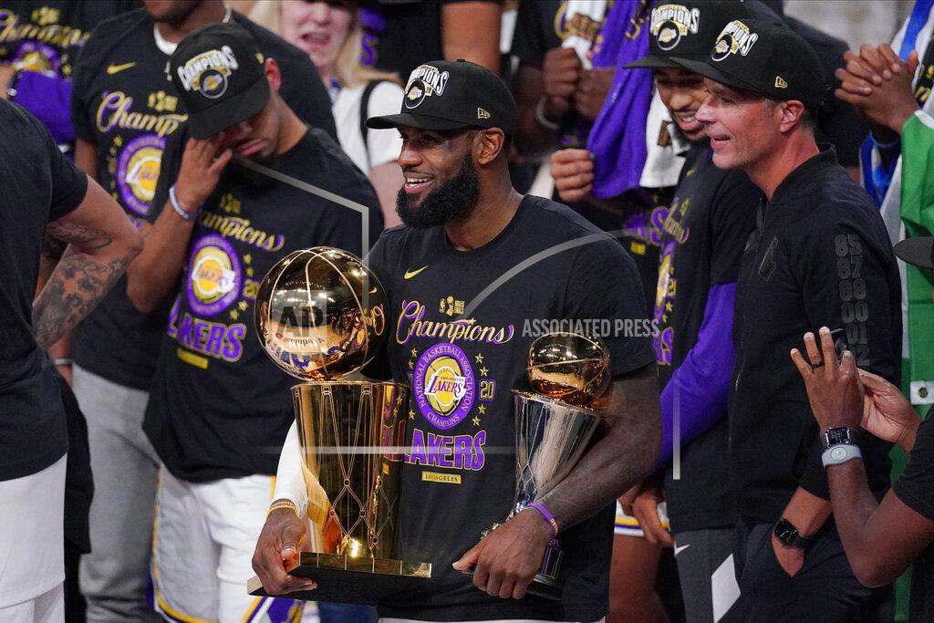Mark J. Terrill FILE - In this Oct. 11, 2020, file photo, Los Angeles Lakers' LeBron James (23) holds the trophies as he celebrates with his teammates after the Lakers defeated the Miami Heat 106-93 in Game 6 of basketball's NBA Finals in Lake Buena Vista, Fla. James was announced Saturday, Dec. 26, as the winner of The Associated Press’ Male Athlete of the Year award for a record-tying fourth time. (AP Photo/Mark J. Terrill, File)