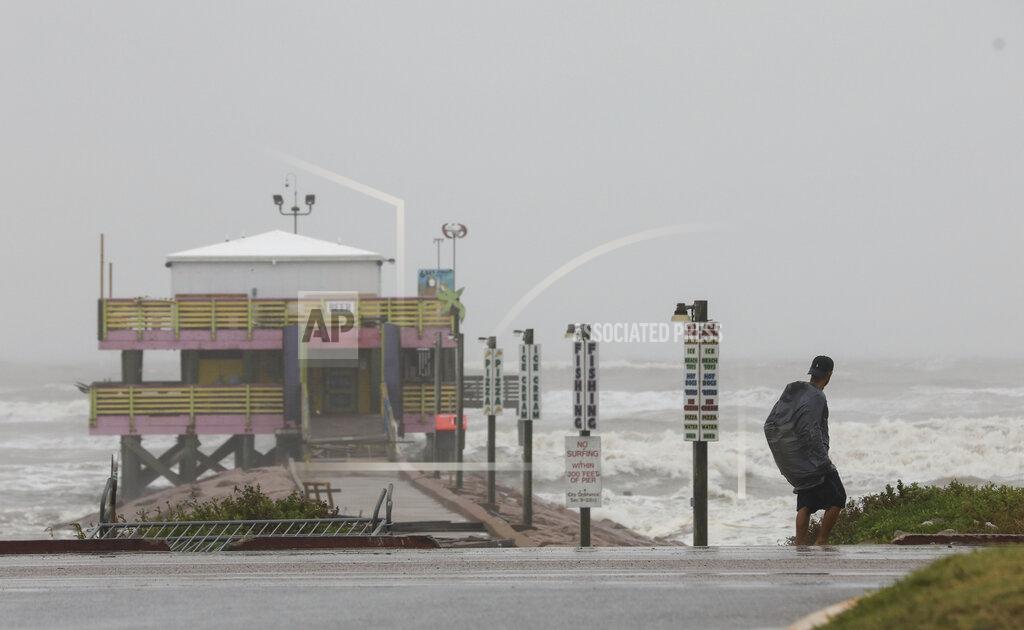 Jon Shapley A man walks down Seawall Boulevard near 61st Street on Tuesday, Sept. 14, 2021, in Galveston, Texas. Hurricane Nicholas made landfall early in the morning along the coast. (Jon Shapley/Houston Chronicle via AP)