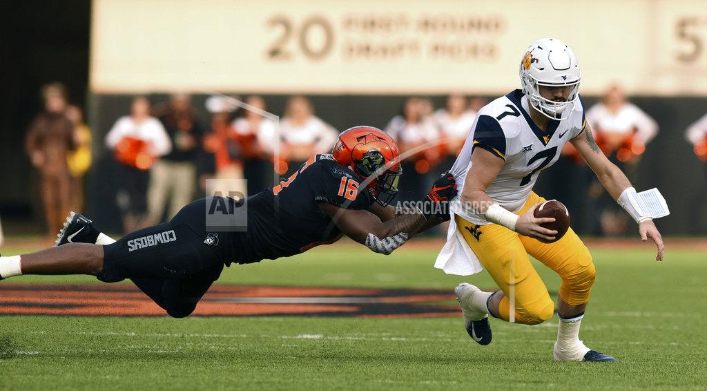 Brody Schmidt Oklahoma State linebacker Devin Harper (16) grabs the jersey of West Virginia quarterback Will Grier (7) during the first half of an NCAA college football game in Stillwater, Okla., Saturday, Nov. 17, 2018. Grier had 2 touchdowns in the 41-45 loss to Oklahoma State. (AP Photo/Brody Schmidt)