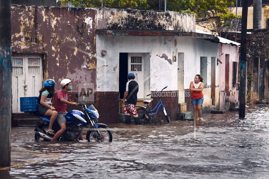 A couple rides a motorcycle along a flooded street after the passing of Hurricane Delta in Tizimin, Mexico, Wednesday, Oct. 7, 2020. Hurricane Delta made landfall Wednesday just south of the Mexican resort of Cancun as a Category 2 storm, downing trees and knocking out power to some resorts along the northeastern coast of the Yucatan Peninsula. (AP Photo/Andres Kudacki)
