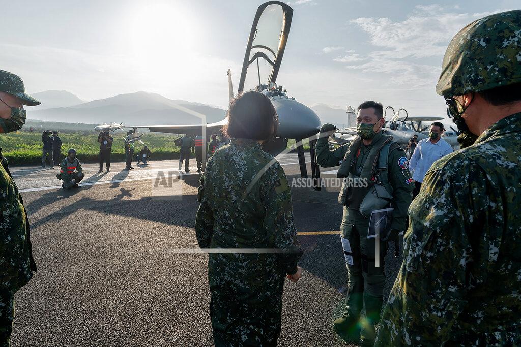 Uncredited In this photo released by the Taiwan Presidential Office, Taiwanese President Tsai Ing-wen, center, speaks with military personnel near aircraft parked on a highway in Jiadong, Taiwan, Wednesday, Sept. 15, 2021. Four military aircraft landed on the highway and took off again on Wednesday as part of Taiwan's five-day Han Guang military exercise designed to prepare the island's forces for an attack by China, which claims Taiwan as part of its own territory. (Taiwan Presidential Office via AP)