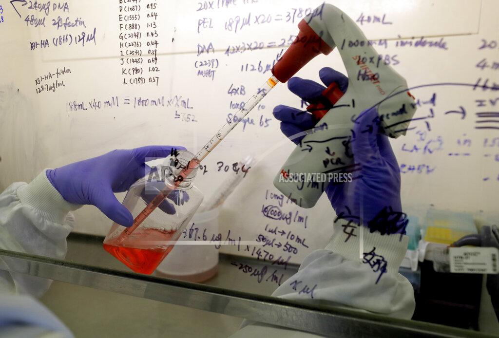 Kirsty Wigglesworth FILE - In this July 30, 2020 file photo, Kai Hu, a research associate transfers medium to cells, in the laboratory at Imperial College in London. Imperial College is working on the development of a COVID-19 vaccine. Refrigeration, cargo planes, and, above all, money: All risk being in short supply for the international initiative to get coronavirus vaccines to the world’s most vulnerable people. (AP Photo/Kirsty Wigglesworth, File)