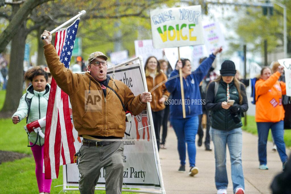 Mark Mirko FILE — In this April 27, 2021 file photo, opponents of a bill to repeal Connecticut's religious exemption for required school vaccinations march down Capitol Avenue before the State Senate voted on legislation, in Hartford, Conn. Religious objections, once used only sparingly around the country to get exempted from various required vaccines, are becoming a much more widely used loophole against the COVID-19 shot. (Mark Mirko/Hartford Courant via AP, File)
