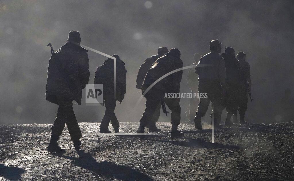 Uncredited FILE - In this Sunday, Nov. 8, 2020 file photo, ethnic Armenian soldiers walk along the road near the border between Nagorno-Karabakh and Armenia. Armenia is taking its decades long territorial dispute with Azerbaijan — that erupted into armed conflict again last year — to the United Nations’ highest court. Armenia filed a case at the International Court of Justice alleging breaches by Azerbaijan of an international convention that aims to eliminate racial discrimination, the court announced late Thursday Sept. 17, 2021. (AP Photo/File)