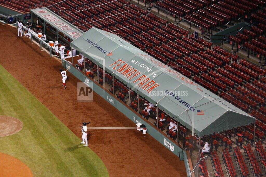 Michael Dwyer Boston Red Sox players spread out in an expanded dugout during the fifth inning of an opening day baseball game against the Baltimore Orioles at Fenway Park, Friday, July 24, 2020, in Boston. (AP Photo/Michael Dwyer)