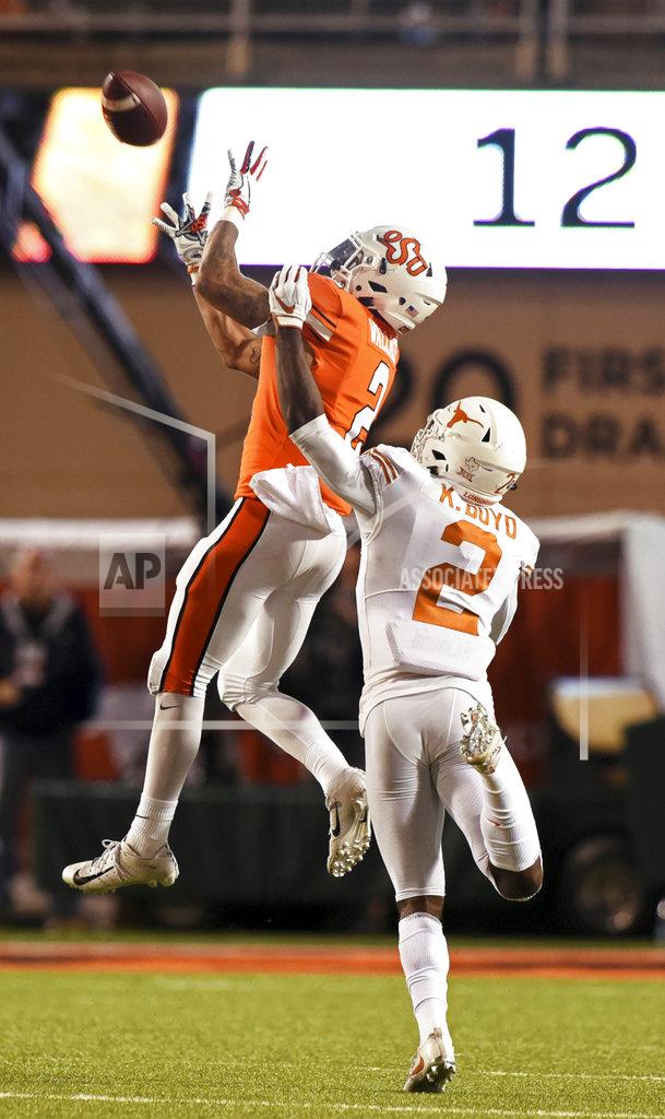 Brody Schmidt Oklahoma State wide receiver Tylan Wallace, left, catches a pass over pressure from Texas defensive back Kris Boyd in the second half of an NCAA college football game in Stillwater, Okla., Saturday, Oct. 27, 2018. Wallace scored 2 touchdowns in the Oklahoma State 38-35 win over Texas. (AP Photo/Brody Schmidt)