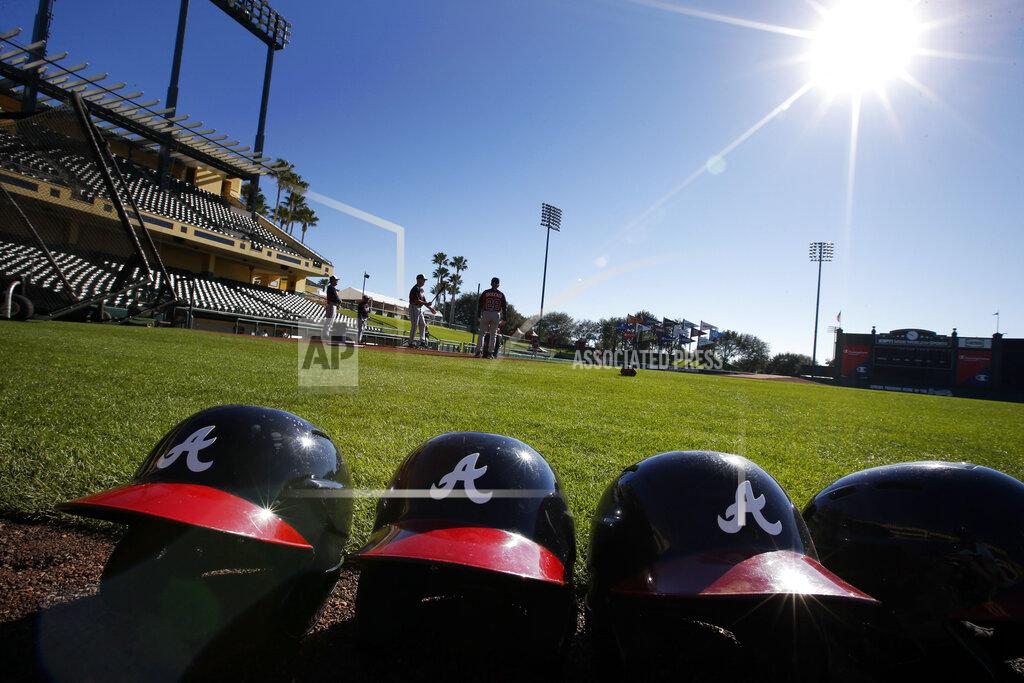 Alex Brandon FILE - In this Feb. 18, 2014, file photo, Atlanta Braves batting helmets sits on the field under a shining sun during a spring training baseball workout in Kissimmee, Fla. Major League Baseball revamped its spring training exhibition schedule because of the pandemic, cutting travel for Florida-based teams in an effort to avoid the novel coronavirus, the league announced Friday, Feb. 12, 2021. (AP Photo/Alex Brandon, File)